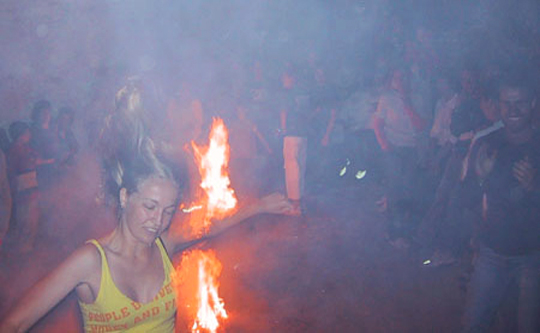 Pretty young girl jumping the fires of Saint John in Ikaria